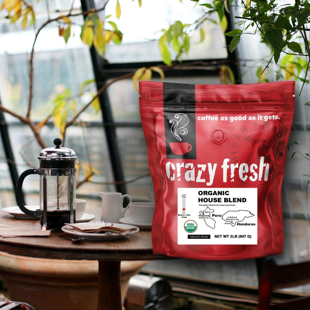 Crazy Fresh Organic House Blend with a French press on a cafe table